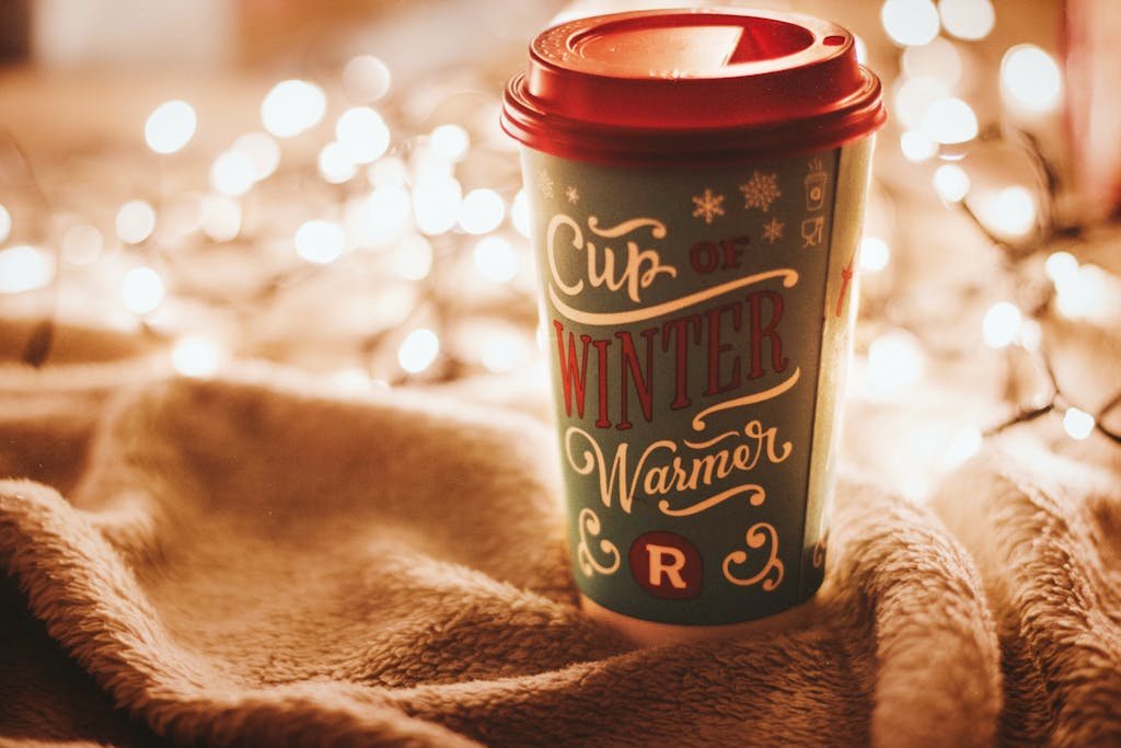 Cozy winter drink in a cup with bokeh fairy lights creates a warm and festive atmosphere.