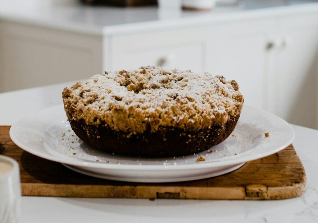 Fresh homemade cake placed on plate in light kitchen in apartment with light interior in daytime