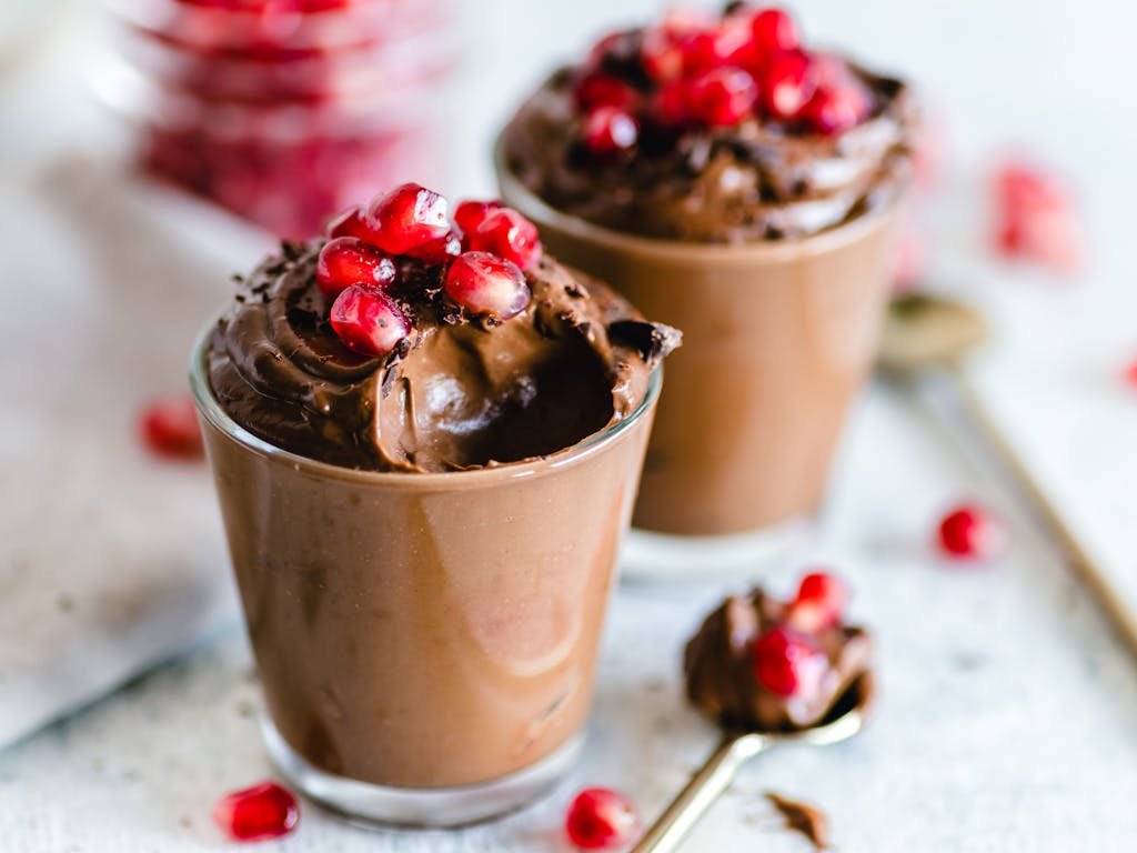 Luscious black garlic chocolate mousse topped with fresh pomegranate seeds, perfect for dessert lovers.