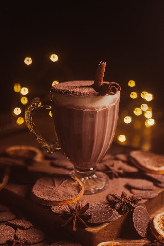 Rich hot chocolate garnished with cinnamon stick and surrounded by warm spices, creating a cozy ambiance.