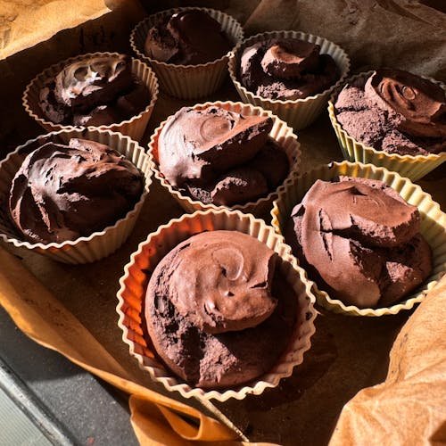 Freshly baked chocolate muffins in silicone cupcake molds, perfect for dessert lovers.